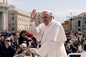 Der Papst vor einer Menschenmenge, winkend
